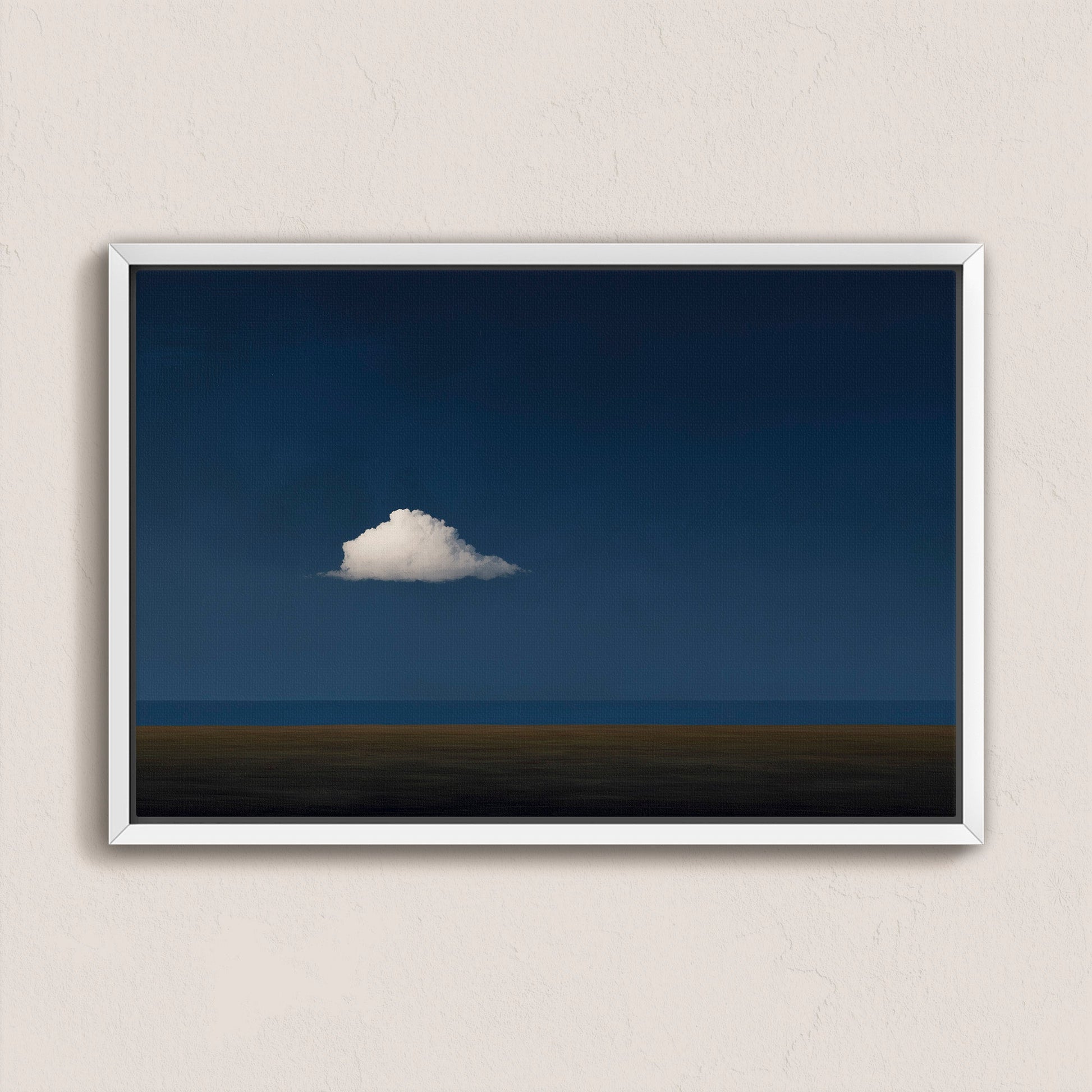 Nimbus canvas print featuring a solitary white cloud over a deep blue horizon in a white frame