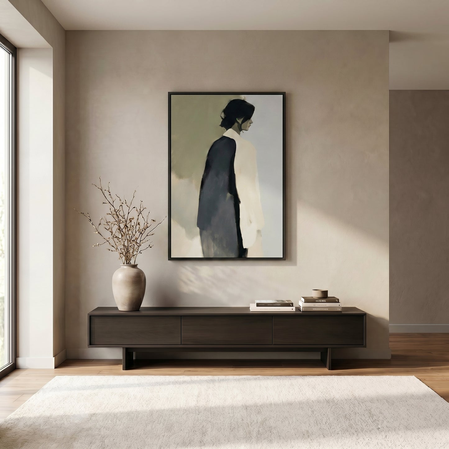 a minimalist living room with a large painting of a person in a black and white outfit hanging on the wall above a dark wooden entertainment center. The entertainment center has a vase of branches and some books on top. The room has a neutral color scheme with a white rug on the floor and a large window providing natural light.