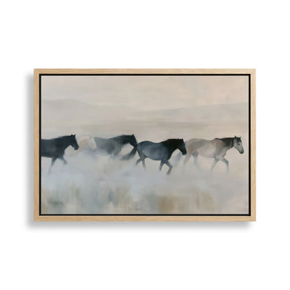 A group of horses running across a field, with a hazy, misty background.
