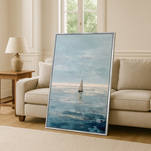 a large painting of a sailboat on the ocean, displayed in a living room setting with a sofa and a lamp.
