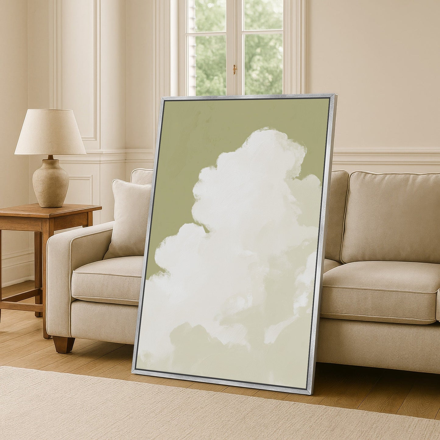 Rise Canvas Wall Art with cloud motif in muted sage tones, framed and leaning against sofa in modern living room