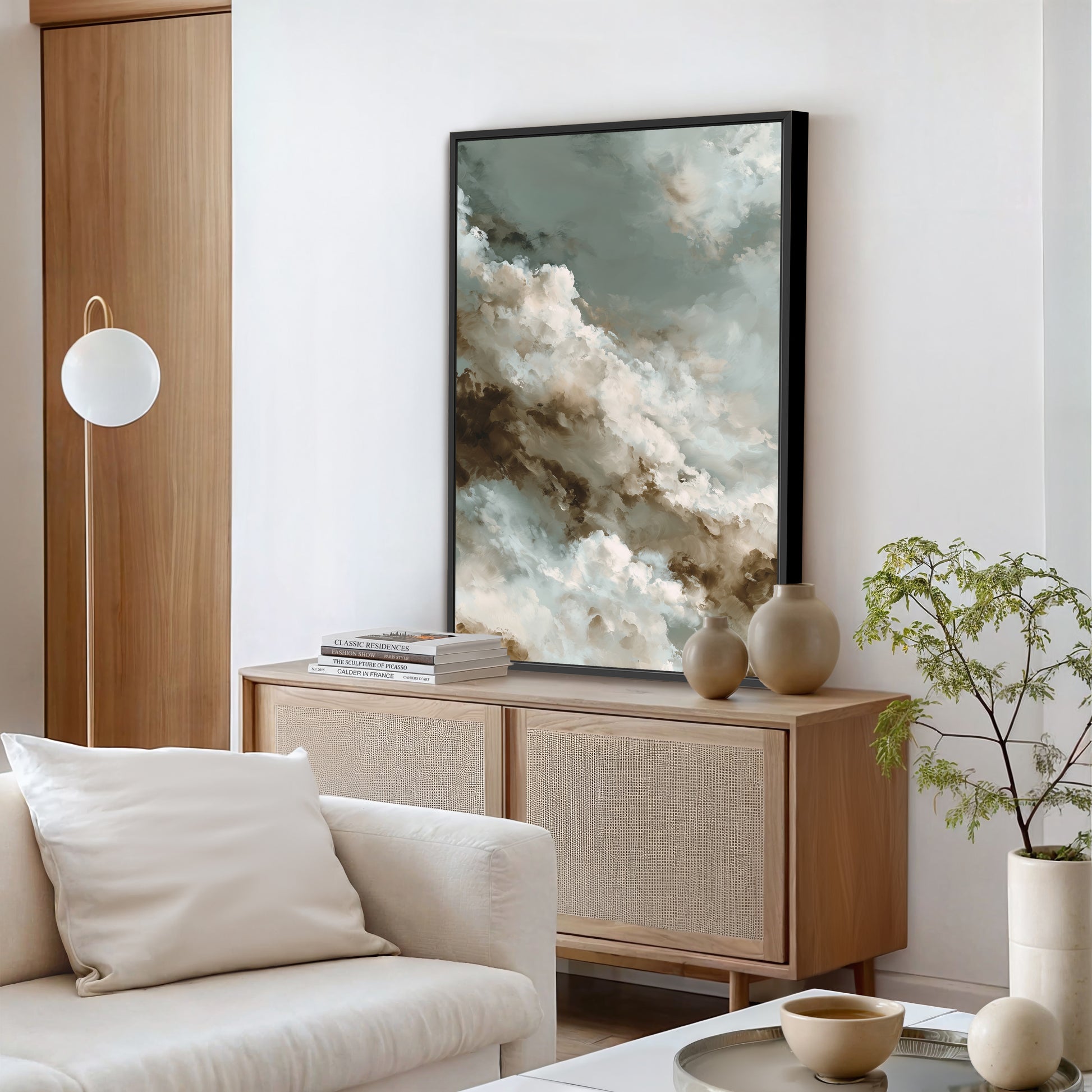 a modern living room with a large abstract painting hanging on the wall above a wooden cabinet. The room is furnished with a white sofa, a coffee table, and a potted plant.