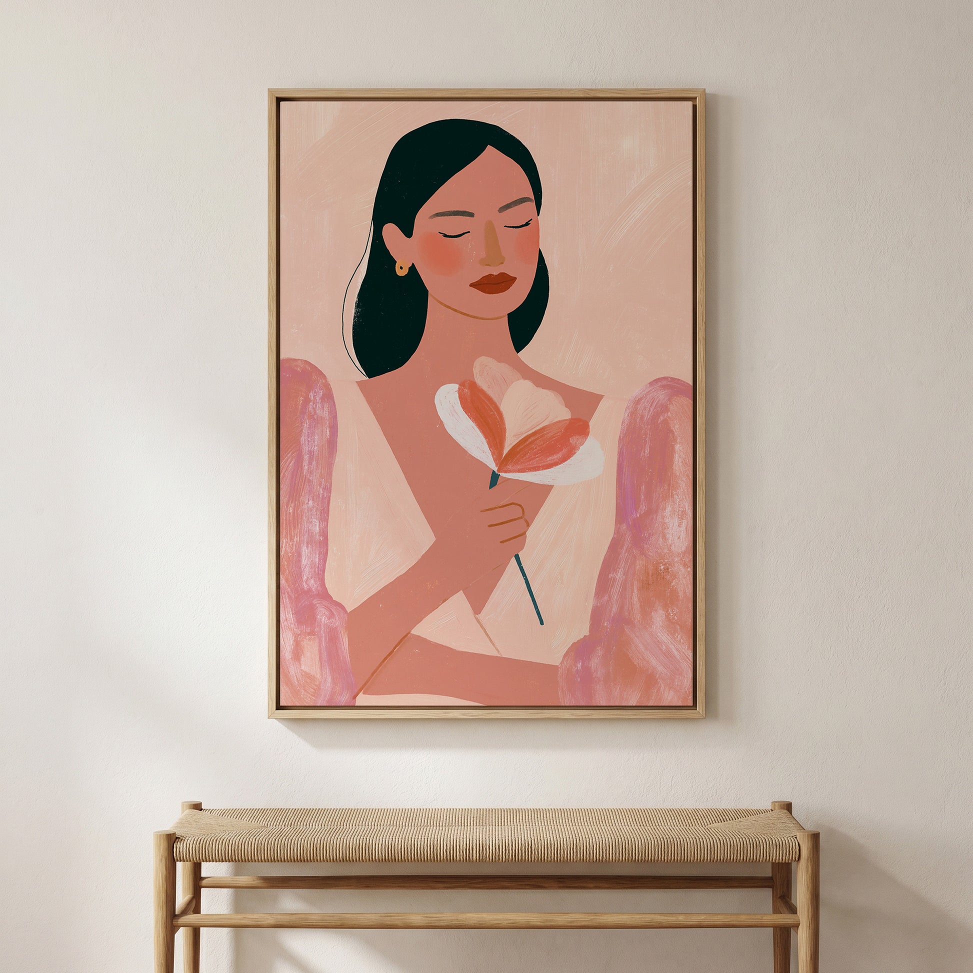 a framed painting of a woman holding a flower, hanging on a wall above a wooden bench.