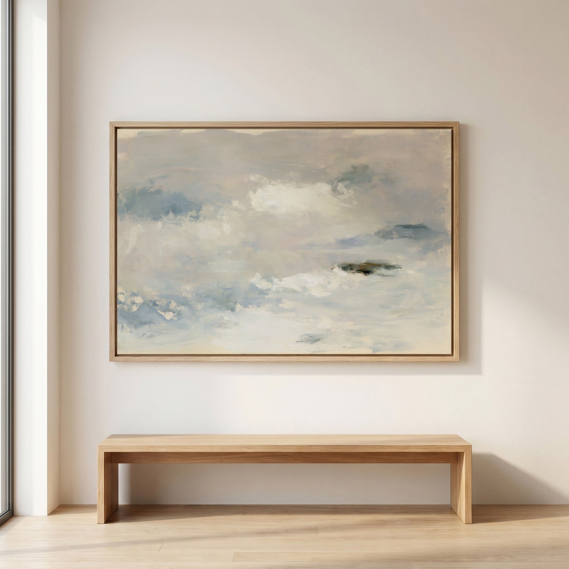 a large, framed painting of a cloudy sky hanging on a wall above a wooden bench.