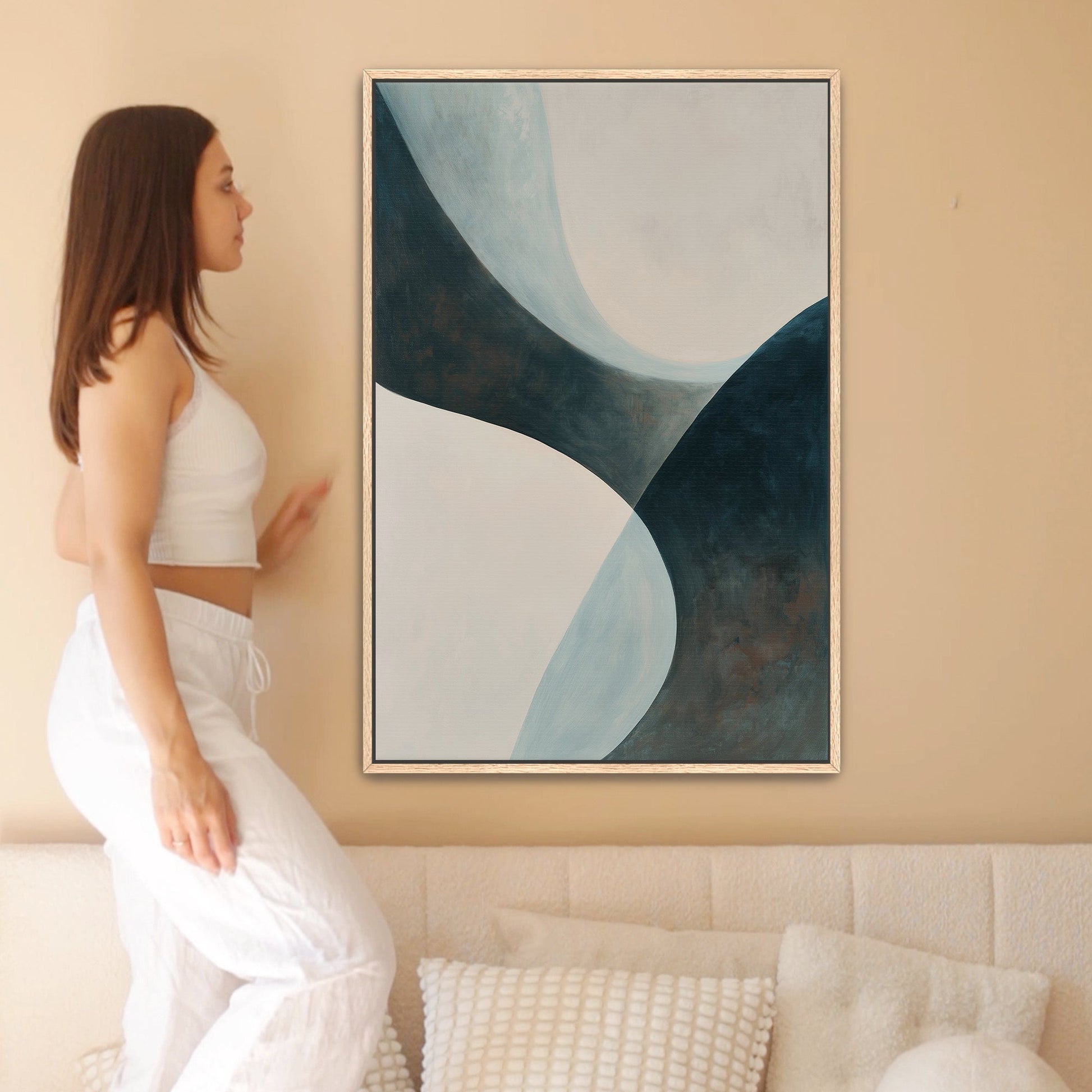 Abstract 'Bend' canvas artwork with soft curves in teal, cream, and muted earth tones, framed and hung on a beige wall.