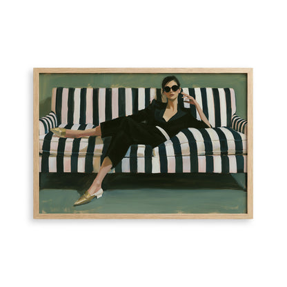 A woman in a black jumpsuit is sitting on a striped couch, wearing gold shoes and sunglasses.