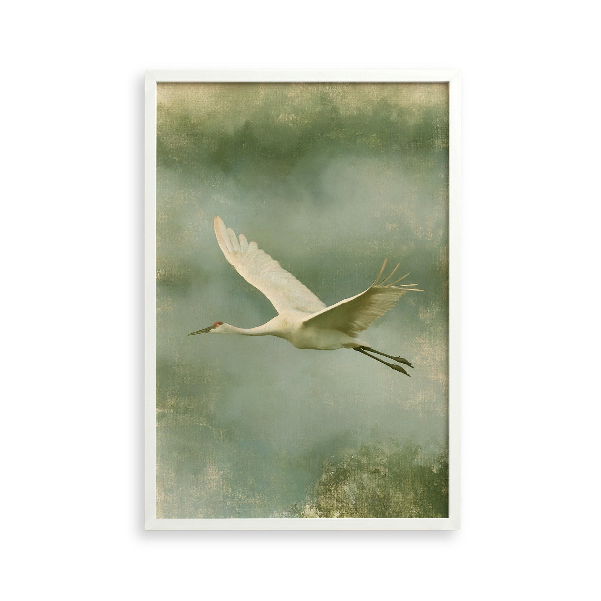 A white crane with outstretched wings is captured in flight against a backdrop of green and gray hues.