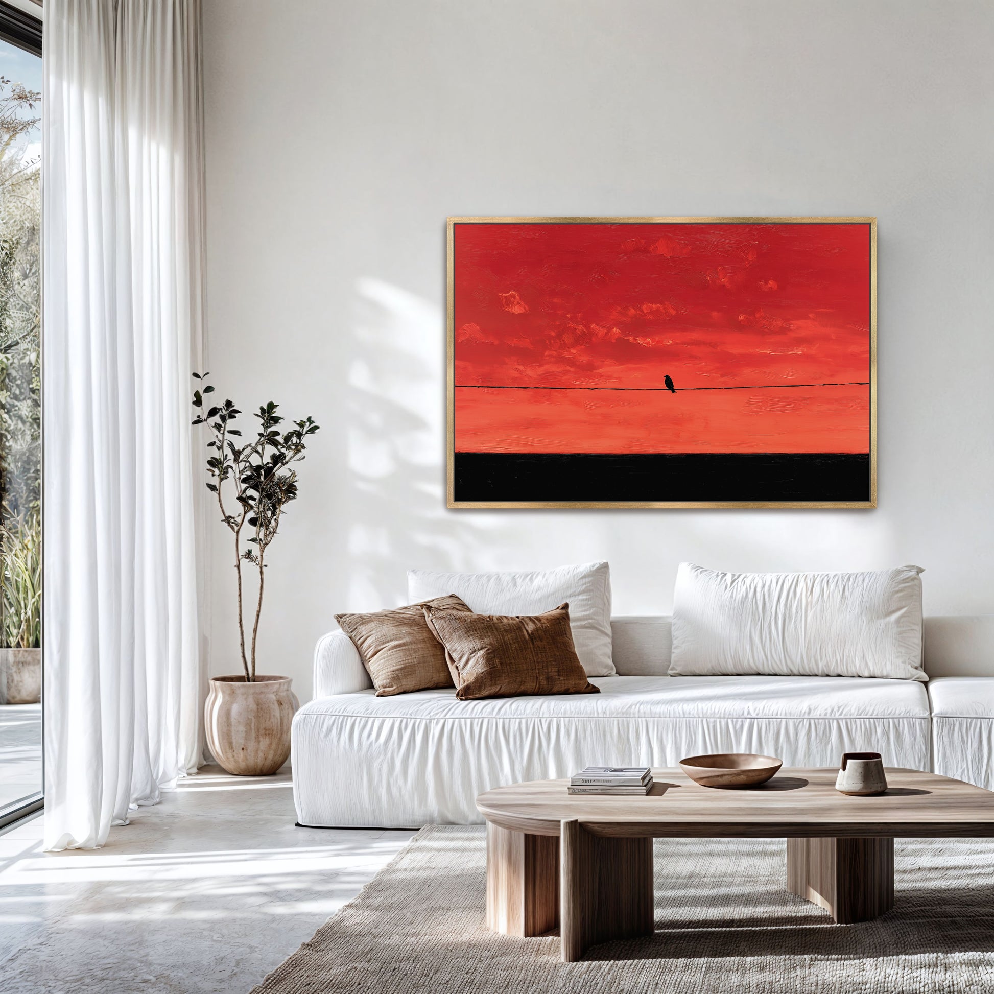 a modern living room with a white sofa, a wooden coffee table, and a large window overlooking a garden. A framed artwork of a bird on a wire is hanging on the wall above the sofa.