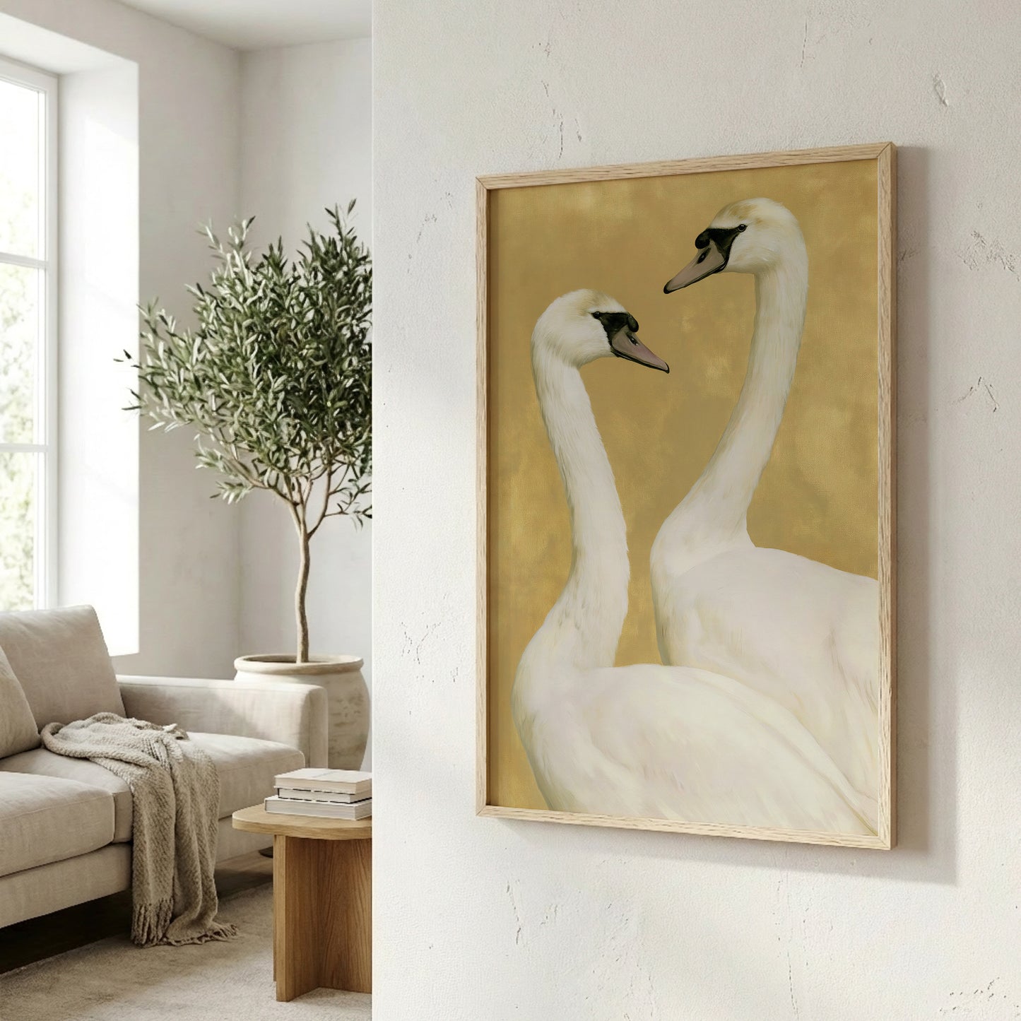 a framed painting of two white swans, hanging on a wall in a living room.