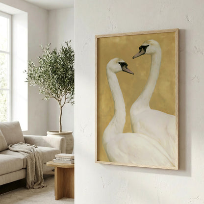 a framed painting of two white swans, hanging on a wall in a living room.