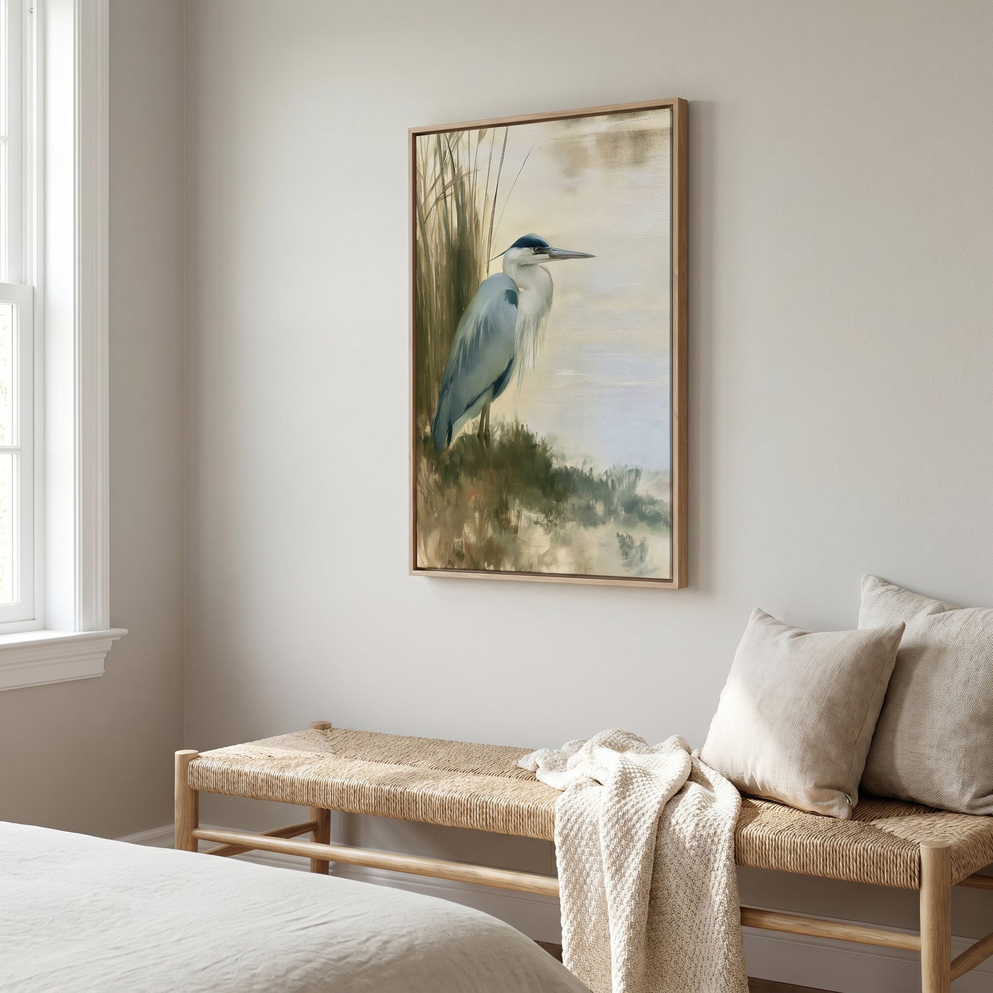a serene bedroom scene with a large painting of a blue heron hanging on the wall above a woven bench.