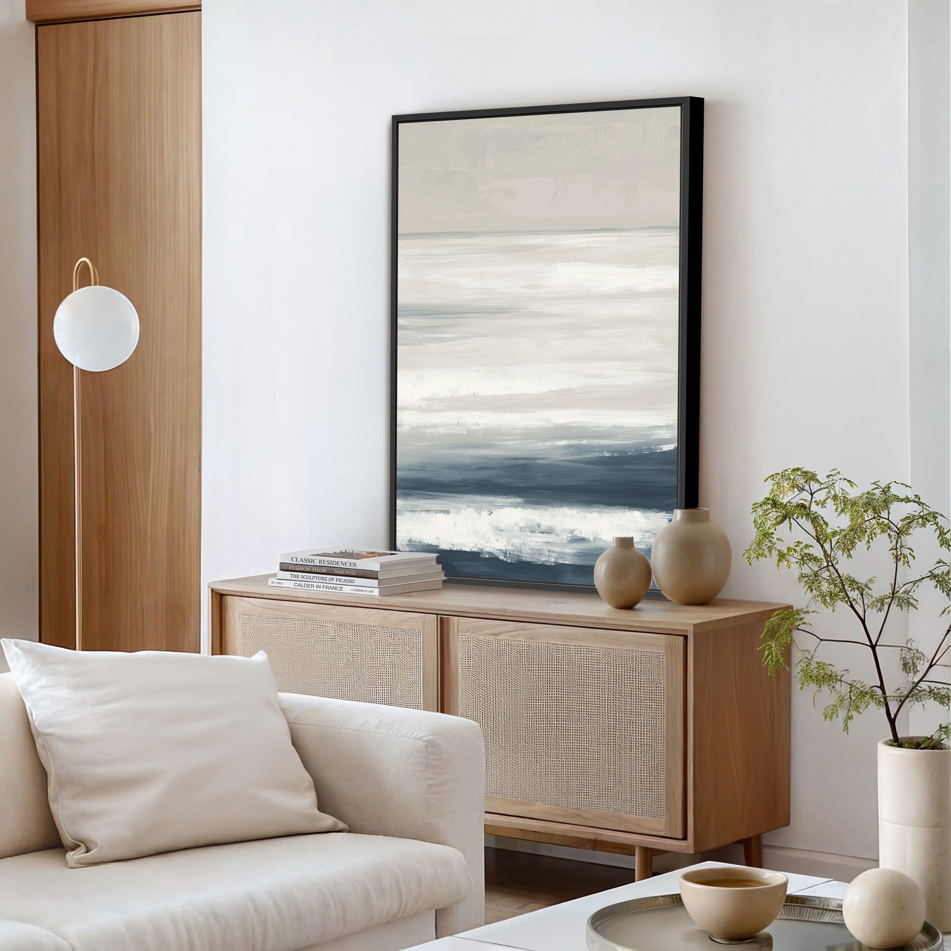 Syd canvas print with ivory, sand, and indigo layers depicting a serene seascape in a modern living room setting