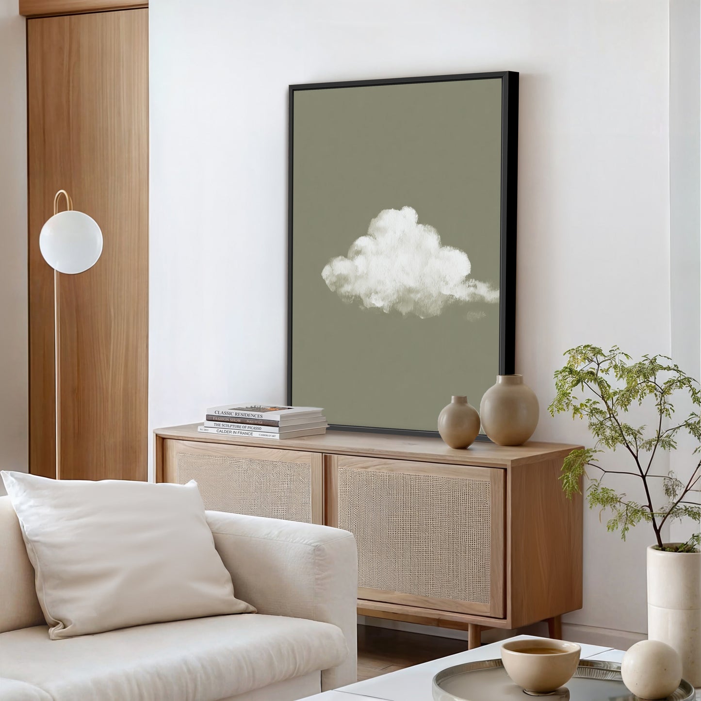 'Trace' canvas print of a single white cloud on a muted sage background in a modern living room setting