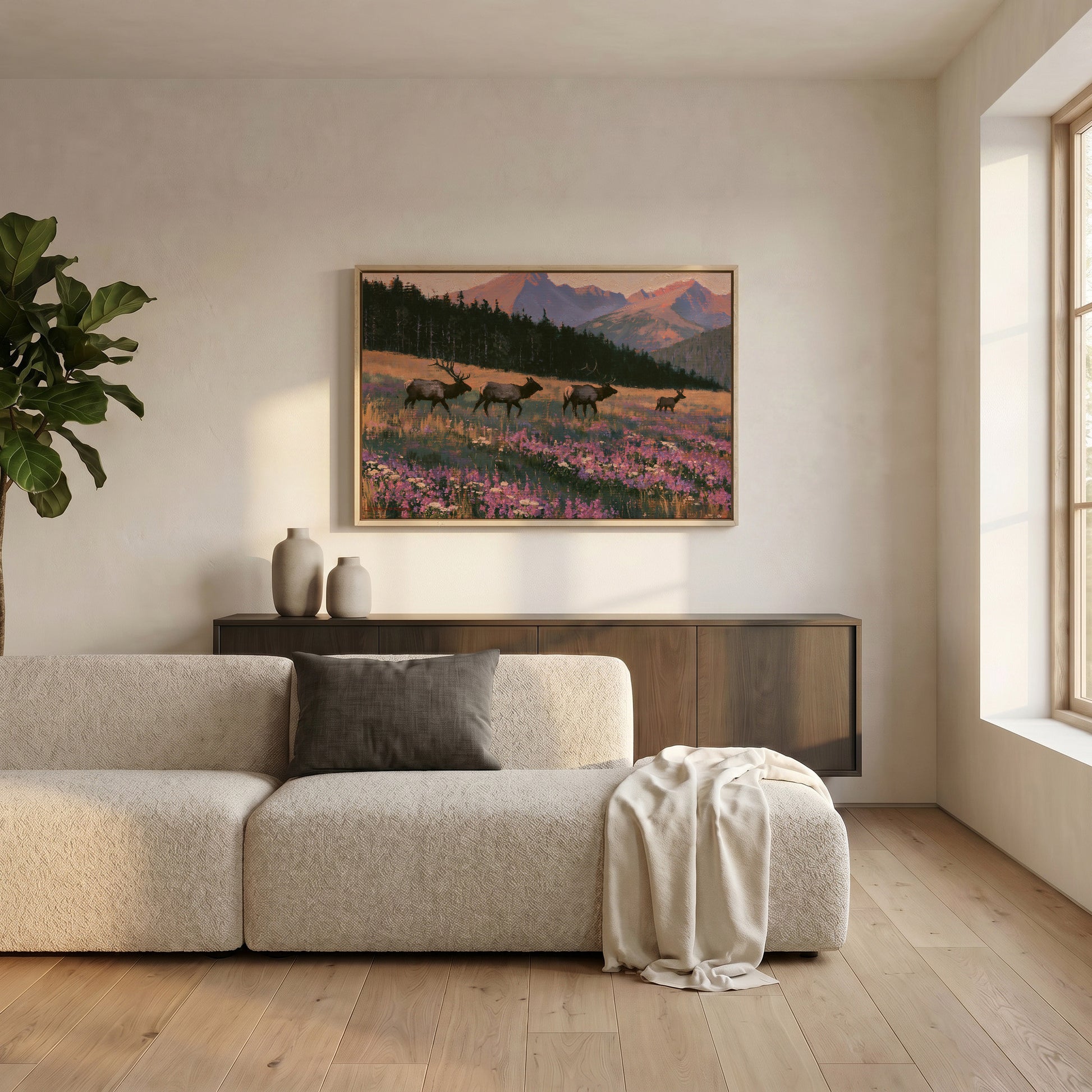 a serene living room with a large window, a beige sofa, a wooden cabinet, and a framed painting of a field with deer in the background.