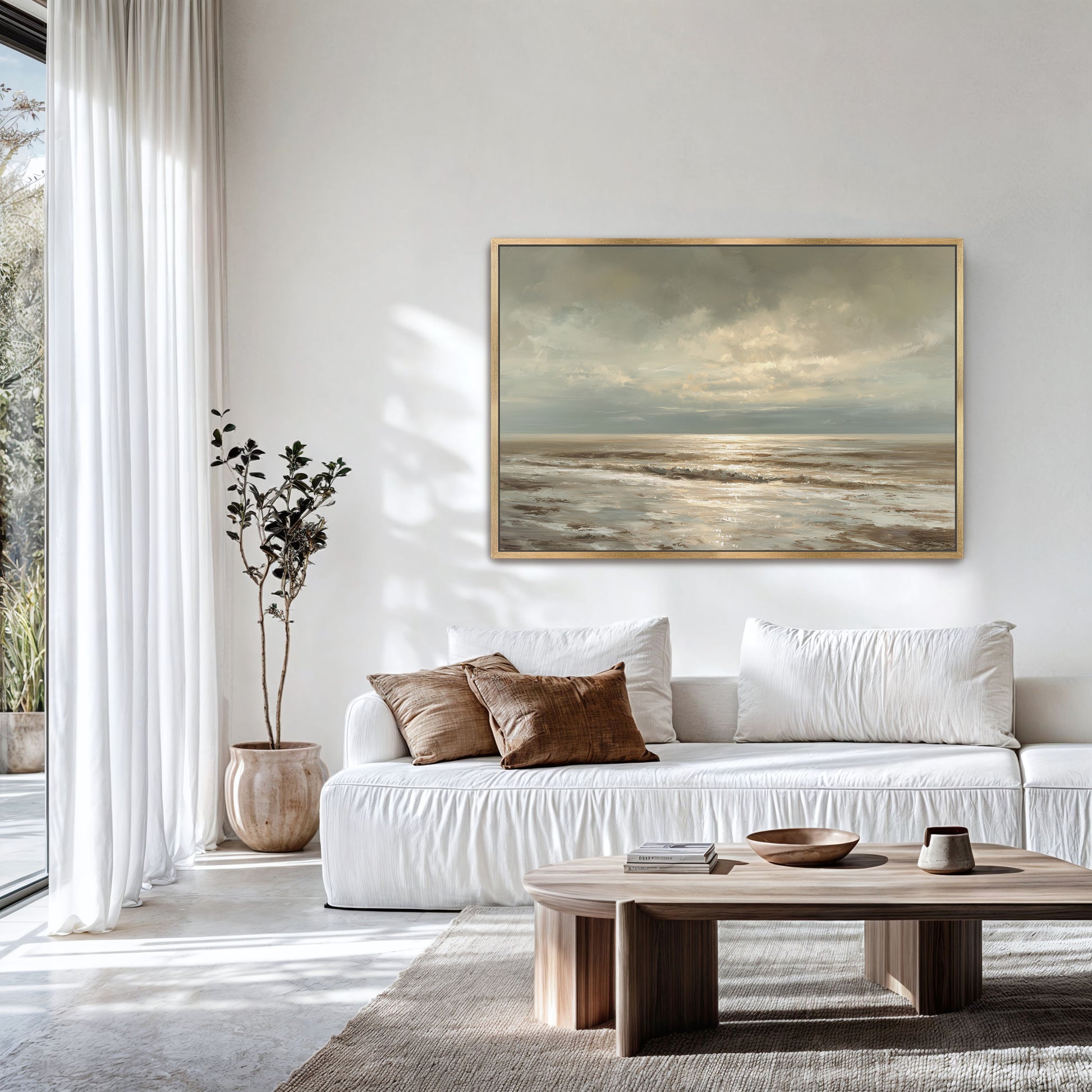a serene living room with a large painting of a beach scene hanging on the wall. The room is decorated with white furniture, including a sofa and a coffee table, and features a large window that allows natural light to fill the space.