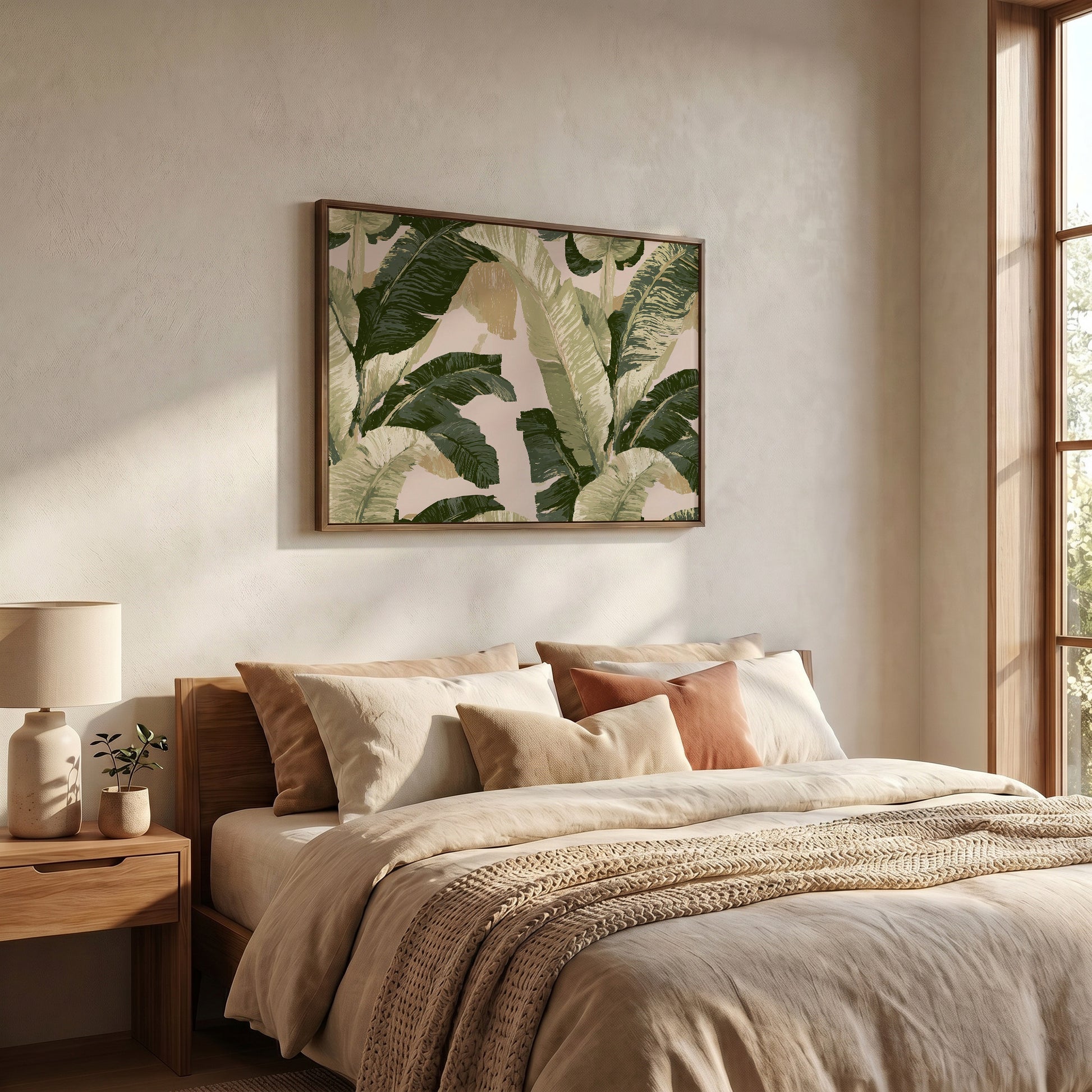 a serene and cozy bedroom with a large bed adorned with beige bedding and a framed print of green palm leaves hanging above it. The room features a wooden nightstand with a lamp, and a window that allows natural light to fill the space.