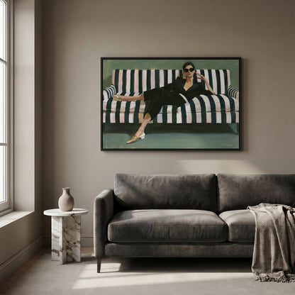 a woman sitting on a striped couch, wearing a black dress and sunglasses.
