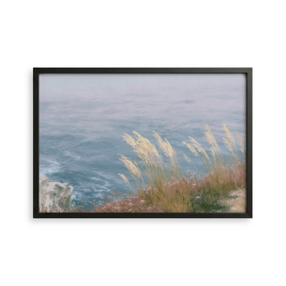 A framed image depicting a serene coastal landscape with a rocky cliff overlooking a vast body of water.