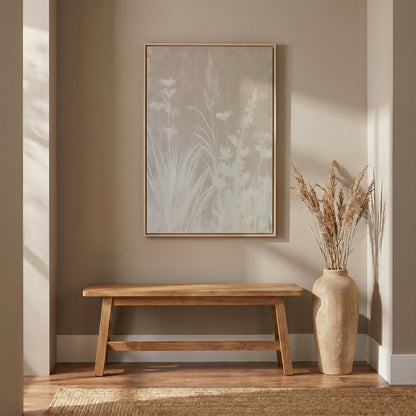 a wooden bench with a vase of dried flowers on a wooden stand, set against a beige wall with a framed picture of a plant on the wall.