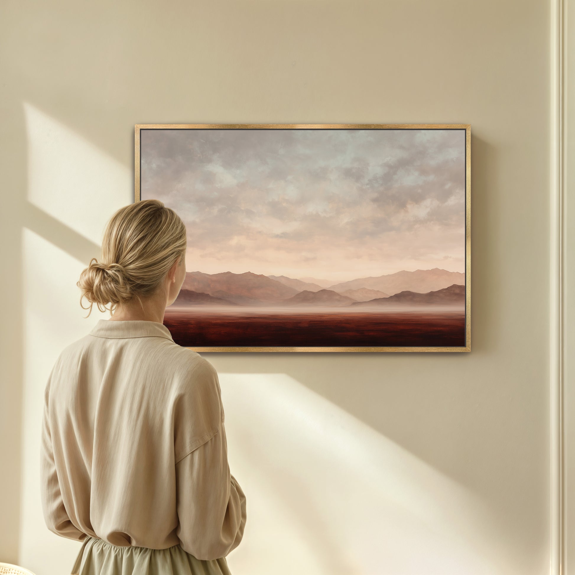 A woman stands in front of a large painting, gazing at the landscape depicted in the artwork.