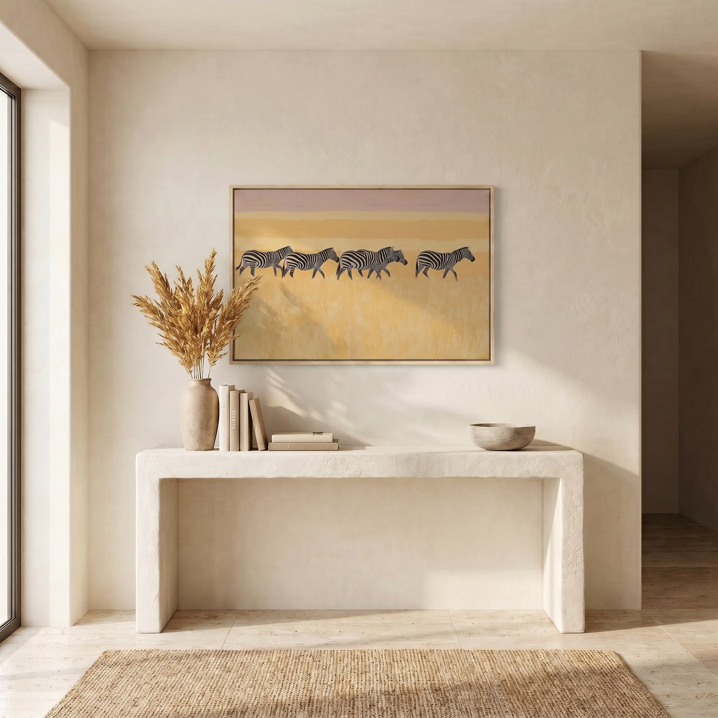 a minimalist interior design with a white console table, a framed painting of zebras, and a vase of dried flowers. The overall color scheme is neutral, with the white console table and the dried flowers adding a touch of warmth and contrast to the space.