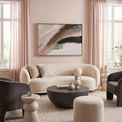 a modern living room with a large abstract painting on the wall, a white sofa, a gray armchair, a round coffee table, and a large window with sheer curtains.