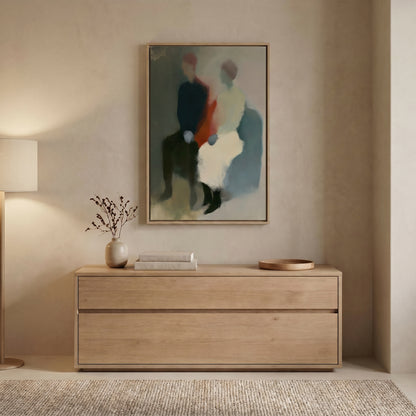 a minimalist interior design with a wooden dresser, a framed abstract painting, and a vase of branches on the dresser.
