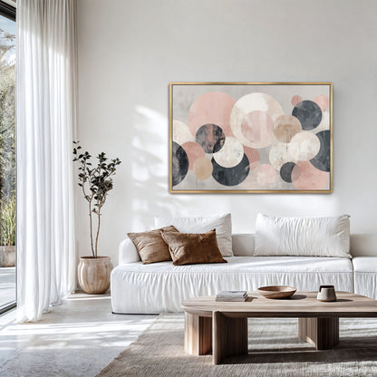 a modern living room with a large abstract painting featuring circles in various shades of pink and gray hanging on the wall above a white sofa. The room has a large window, a wooden coffee table, and a potted plant, creating a cozy and inviting atmosphere.