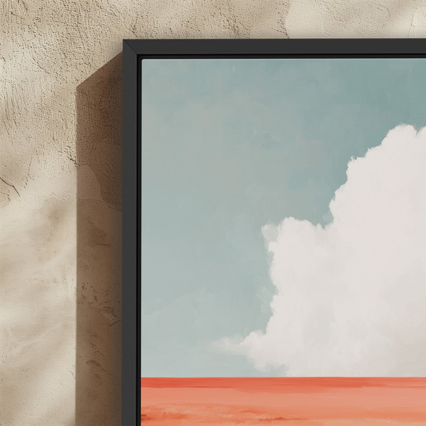 Aurea Canvas Wall Art featuring a lone white cloud over a coral horizon with a soft blue sky in a black frame on textured beige wall
