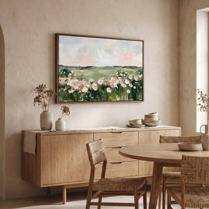 a dining room with a large painting of a field of flowers hanging on the wall above a wooden cabinet. The cabinet has a table and chairs set up in front of it. The room has a neutral color scheme with beige walls and a wooden floor.