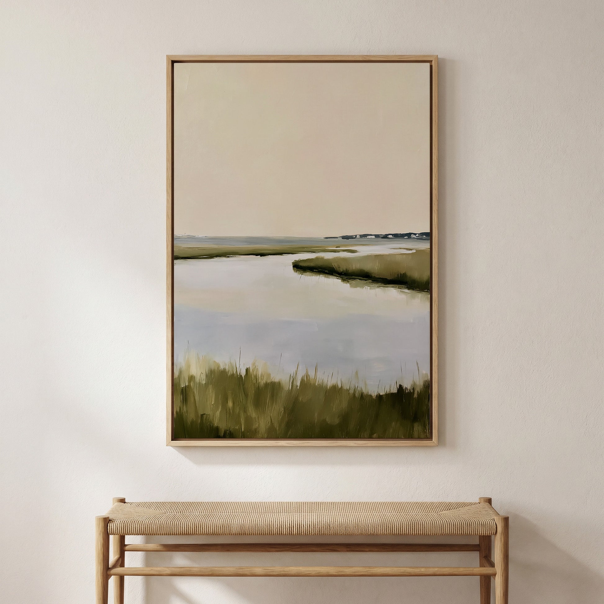 a large painting of a serene landscape with a body of water and grassy terrain, hanging on a wall above a wooden bench.