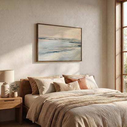 a serene bedroom scene with a large bed adorned with beige bedding and a wooden headboard. Above the bed, a framed painting of a tranquil ocean landscape is displayed on the wall. The room is illuminated by natural light streaming in from a window, creating a warm and inviting atmosphere.