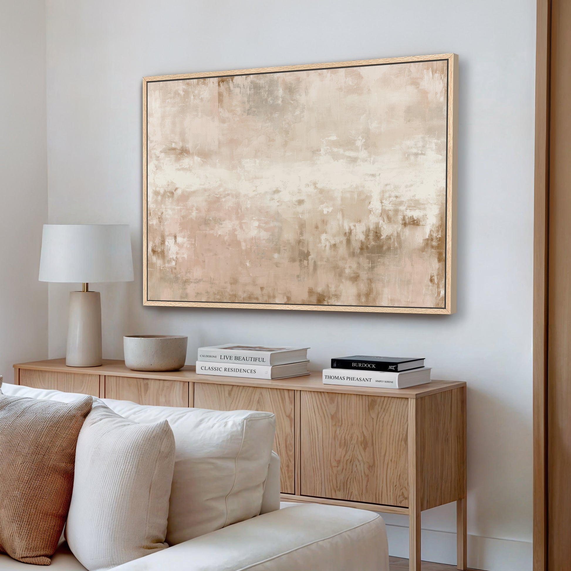 a living room with a white sofa, a wooden sideboard, and a large abstract painting hanging on the wall above the sideboard.
