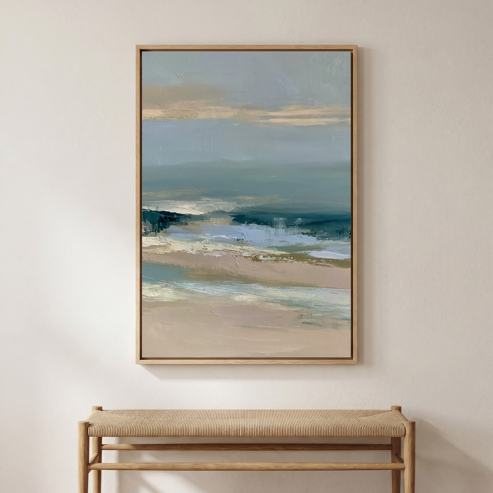 a large, framed painting of a serene landscape depicting a beach scene with a blue sky and ocean. The painting is hung on a wall above a wooden bench, creating a cozy and inviting atmosphere in the room.