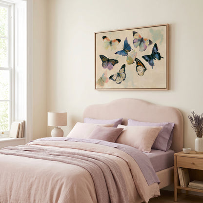 a bedroom with a large bed, a framed artwork of colorful butterflies hanging above it, and a window with white curtains.