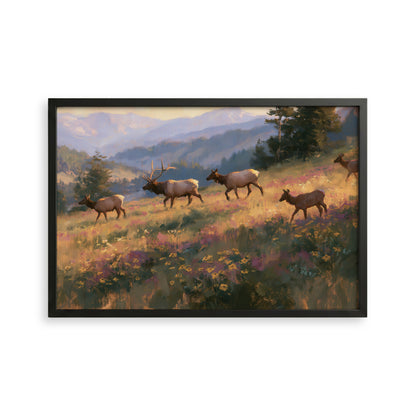A framed painting depicting a group of elk walking through a field of flowers and grass, with mountains in the background.