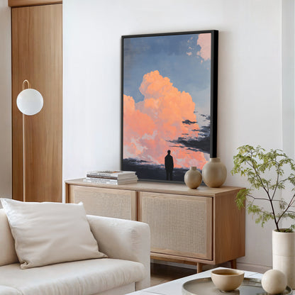 a serene living room with a large framed picture of a person standing in front of a sunset, featuring orange and pink clouds. The room is furnished with a white sofa, a wooden cabinet, and a potted plant, creating a cozy and inviting atmosphere.