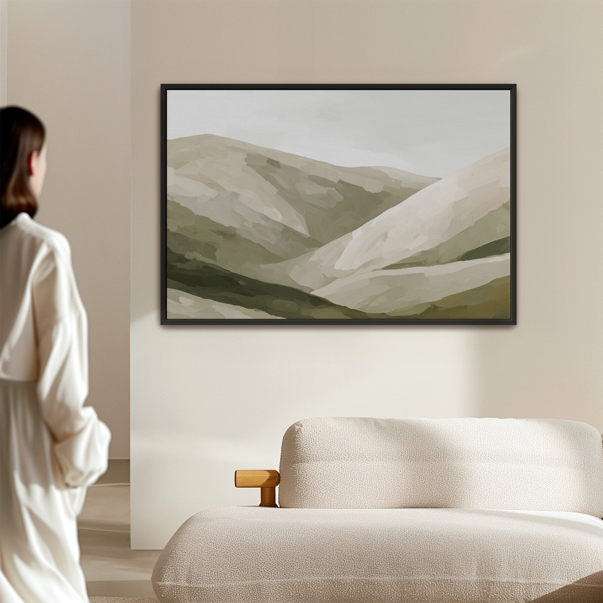 Olive Hills canvas print with layered neutral-toned hills in a black frame above a beige sofa in a minimalist room