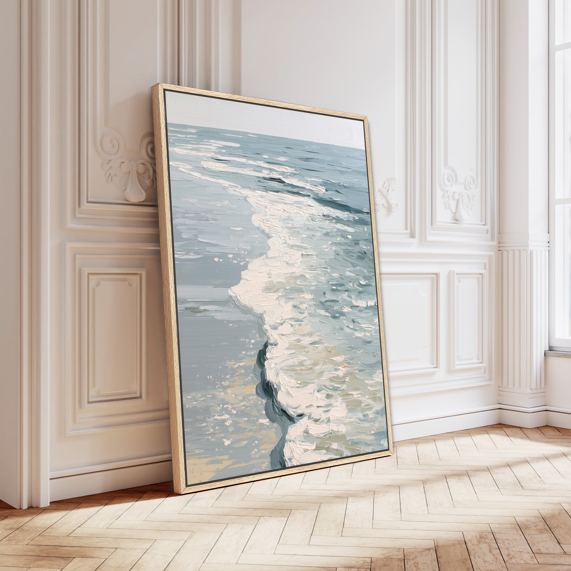 A large framed painting depicting a serene ocean scene is leaning against a white wall in a room with a wooden floor.