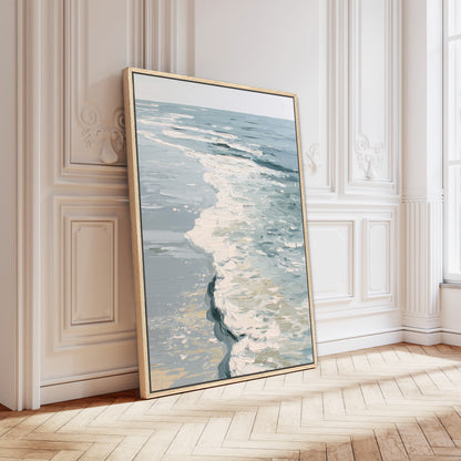 A large framed painting depicting a serene ocean scene is leaning against a white wall in a room with a wooden floor.