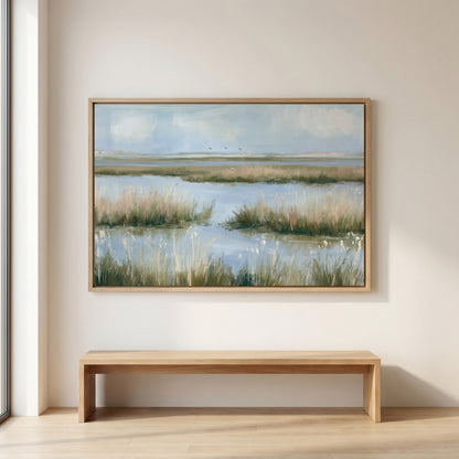 a large painting of a serene landscape with a body of water and tall grass, hanging on a wall above a wooden bench.