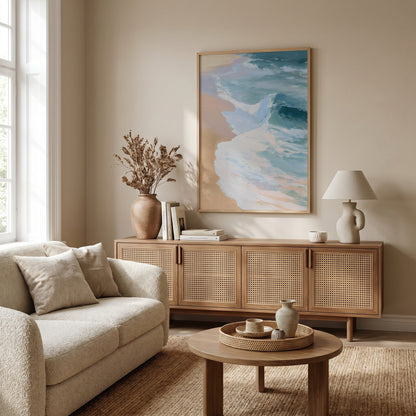 a cozy living room with a beige sofa, a wooden sideboard, and a large framed artwork of a beach scene hanging on the wall.