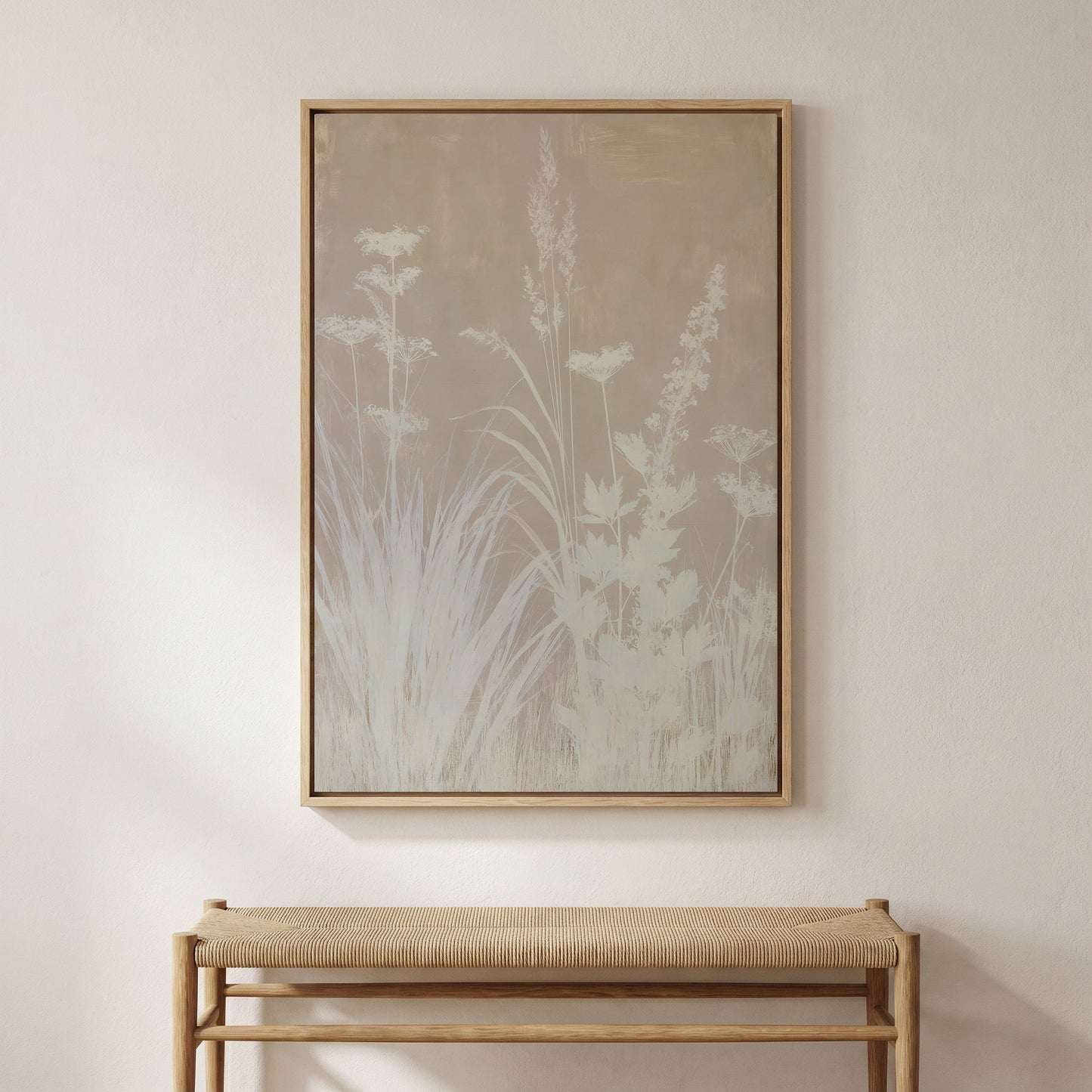 a large framed artwork of white flowers hanging on a wall above a wooden bench.