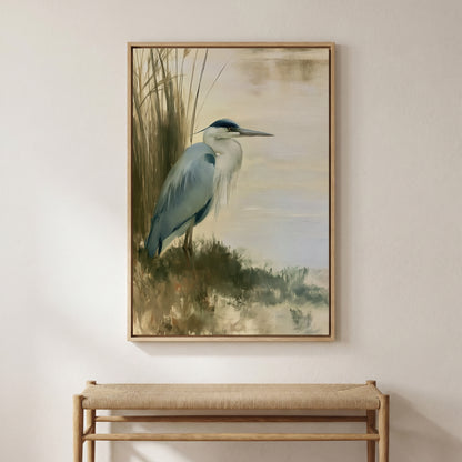 a framed painting of a blue heron standing in tall grass near a body of water.
