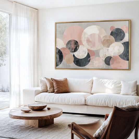 a modern living room with a large abstract painting featuring circles in various shades of pink, blue, and gray hanging on the wall above a white sofa.
