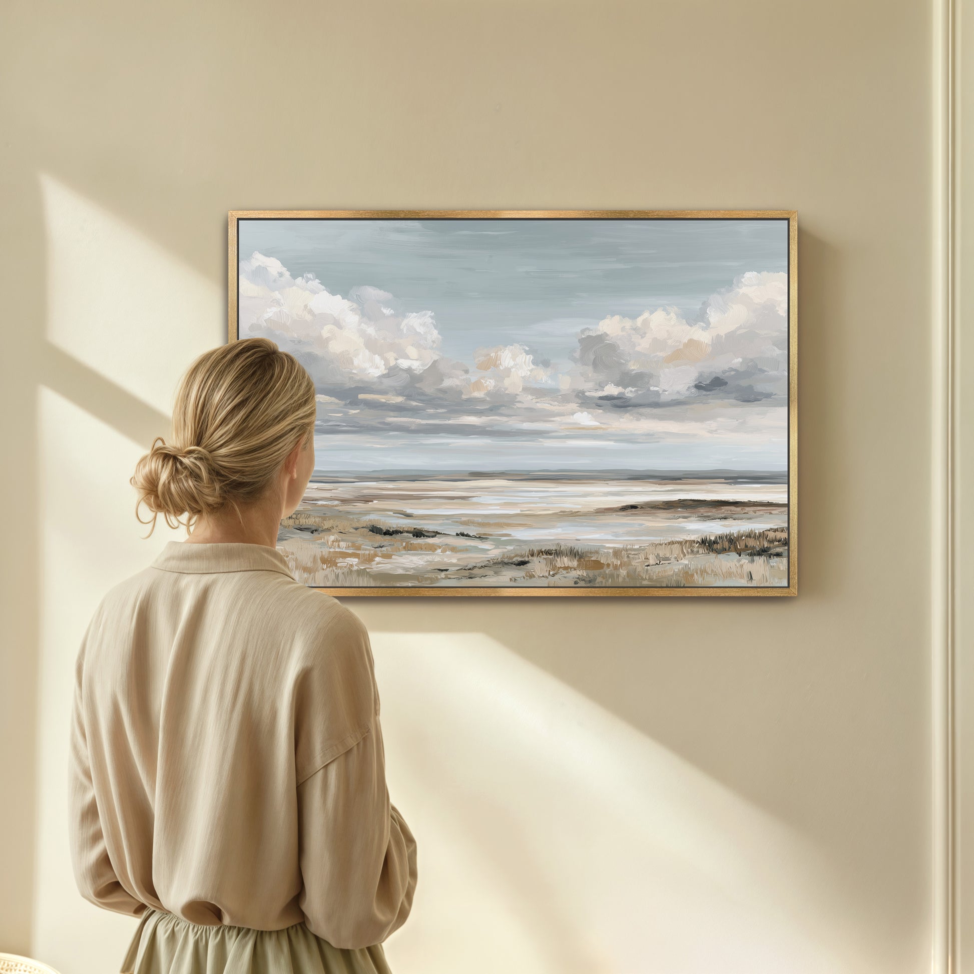 A woman stands in front of a large painting, gazing at the landscape depicted in the artwork.