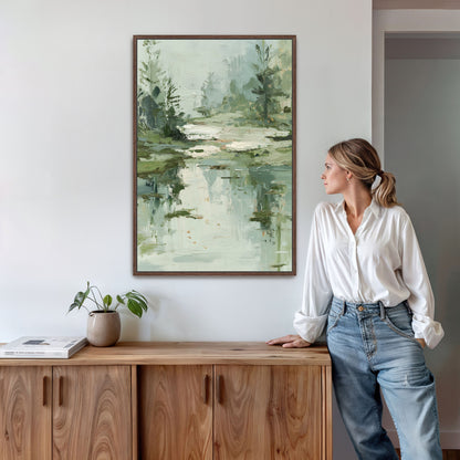 A woman stands in a room, leaning against a wooden cabinet, with a framed landscape painting hanging on the wall above her.