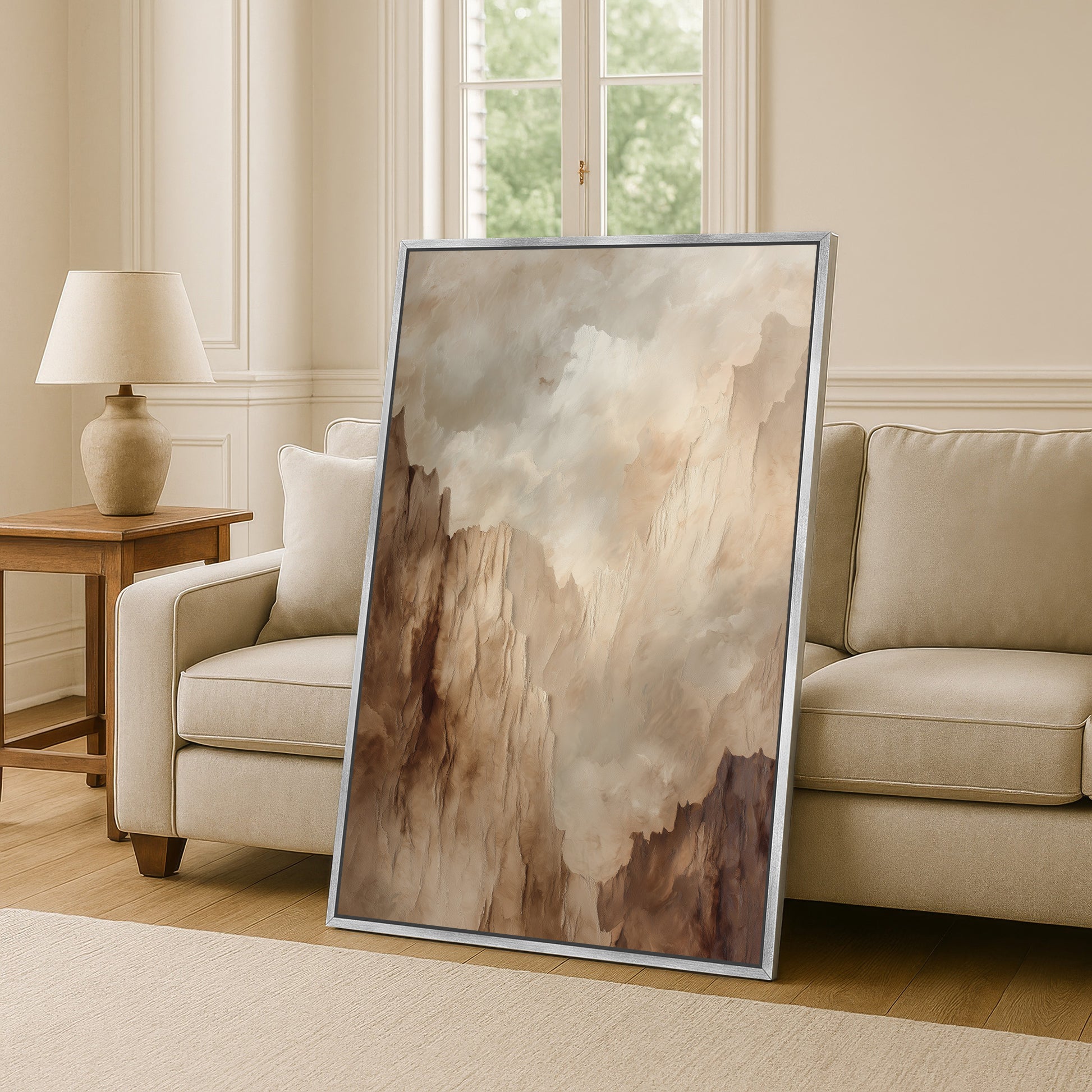 a large, framed painting of a landscape with a cloudy sky, placed on a wooden floor in a living room setting.