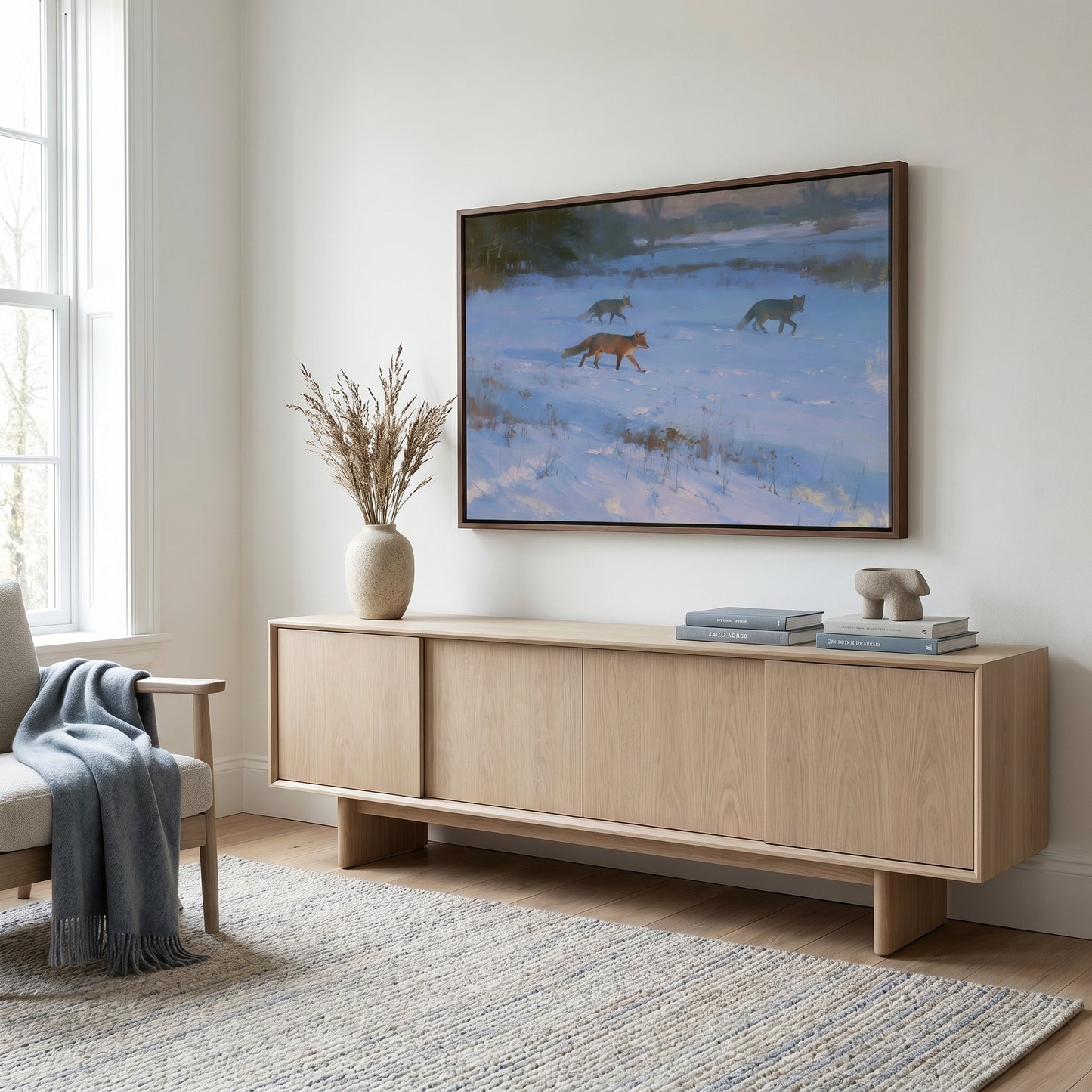 a cozy living room with a large wooden entertainment center, a comfortable chair, and a framed painting of three foxes in a snowy landscape.