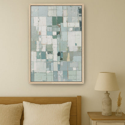 Neutral geometric wall art above bed with beige linens and wooden side table.
